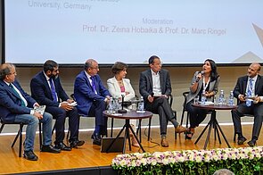 Podium discussion with 7 participants sitting next to each other