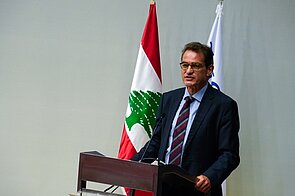 Speaker on a podium with the Lebanon flag in the background