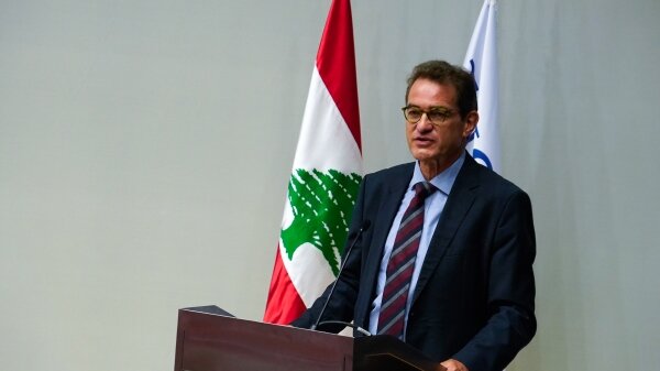 Speaker on a podium with the Lebanon flag in the background