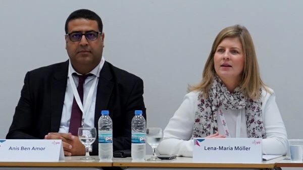 AGYA Members Anis Ben Amor and Lena-Maria Möller sitting on a table