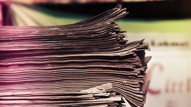 Stack of newspapers in pink light